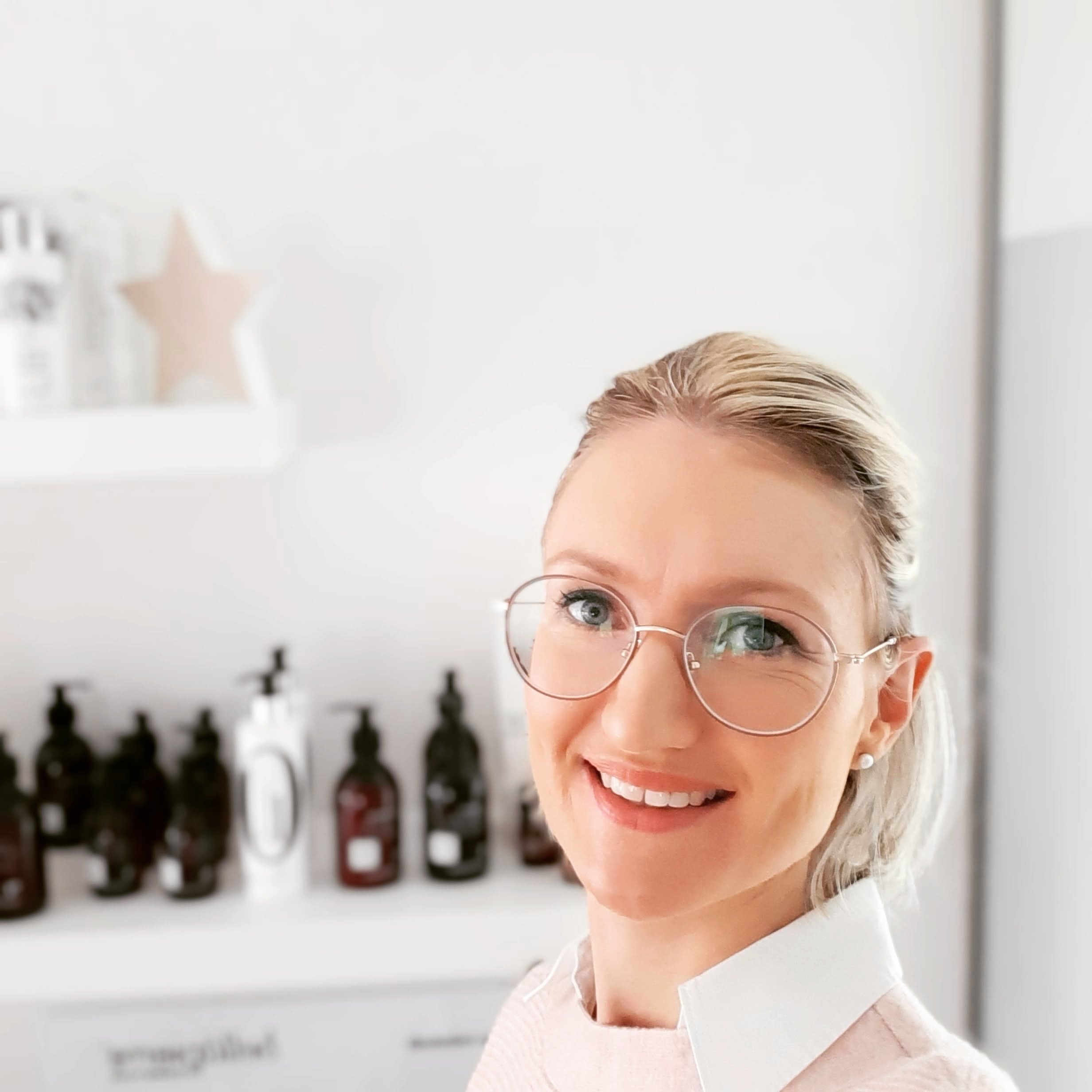 Schoonheidsspecialiste Appelterre/Ninove draagt bril en roze trui met witte blouse