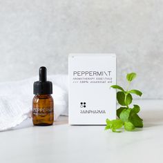 witte verpakking Peppermint, flesje essentiële olie Peppermint, witte handdoek en takje pepermunt